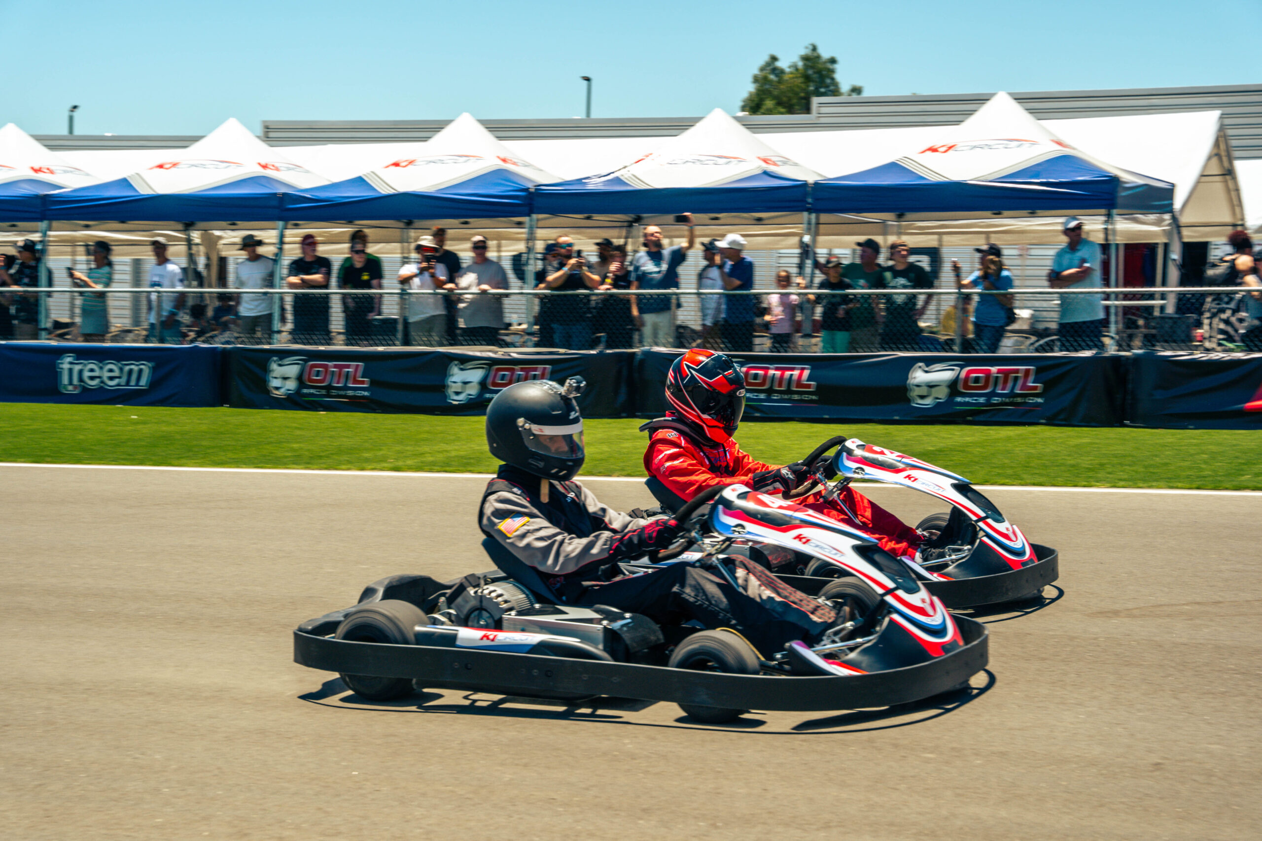 two go karts race side by side on the main straight at k1 circuit