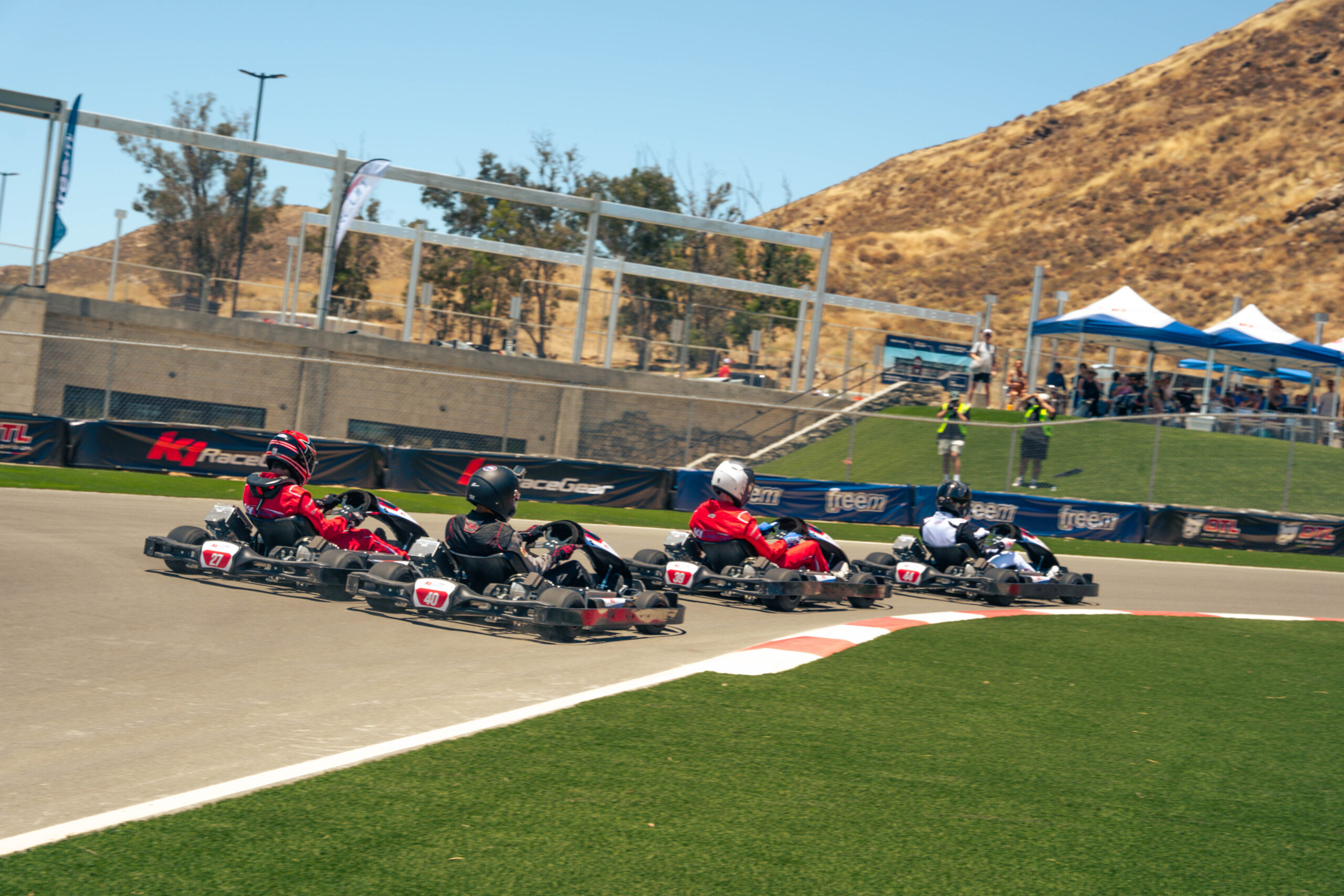 a group of karts heads into turn 1 at k1 circuit