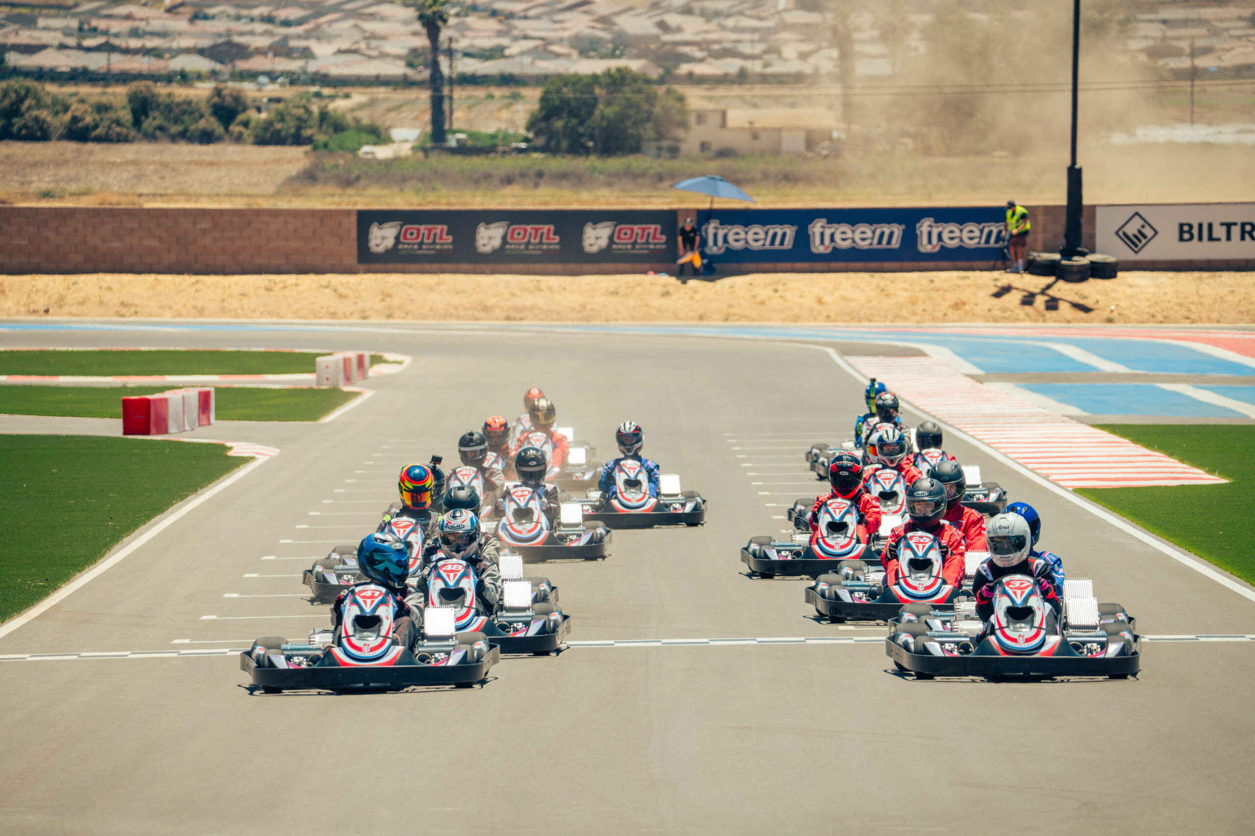 a full grid of go karts take off at the start of a race at k1 circuit