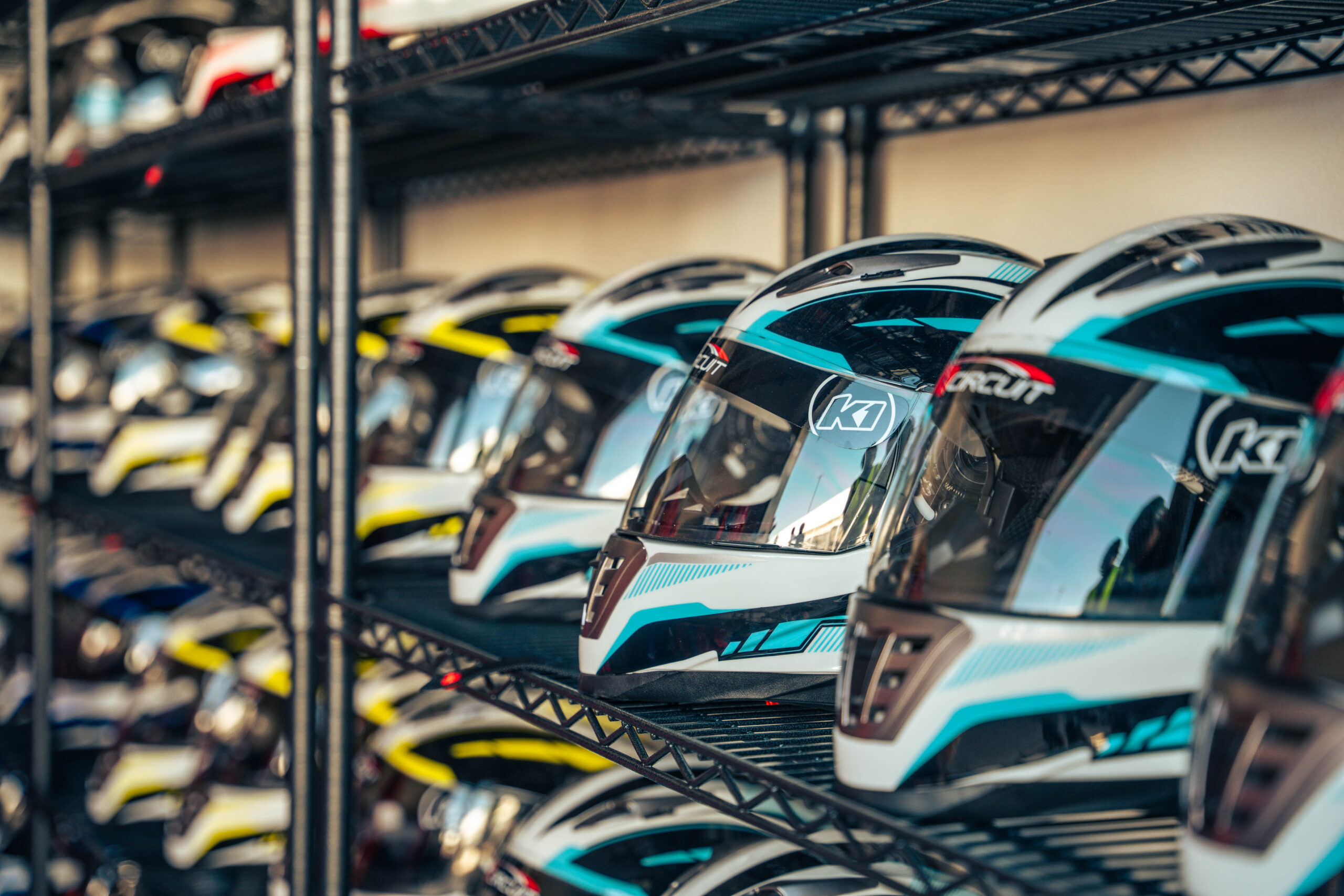 helmets lined up on a rack at k1 circuit